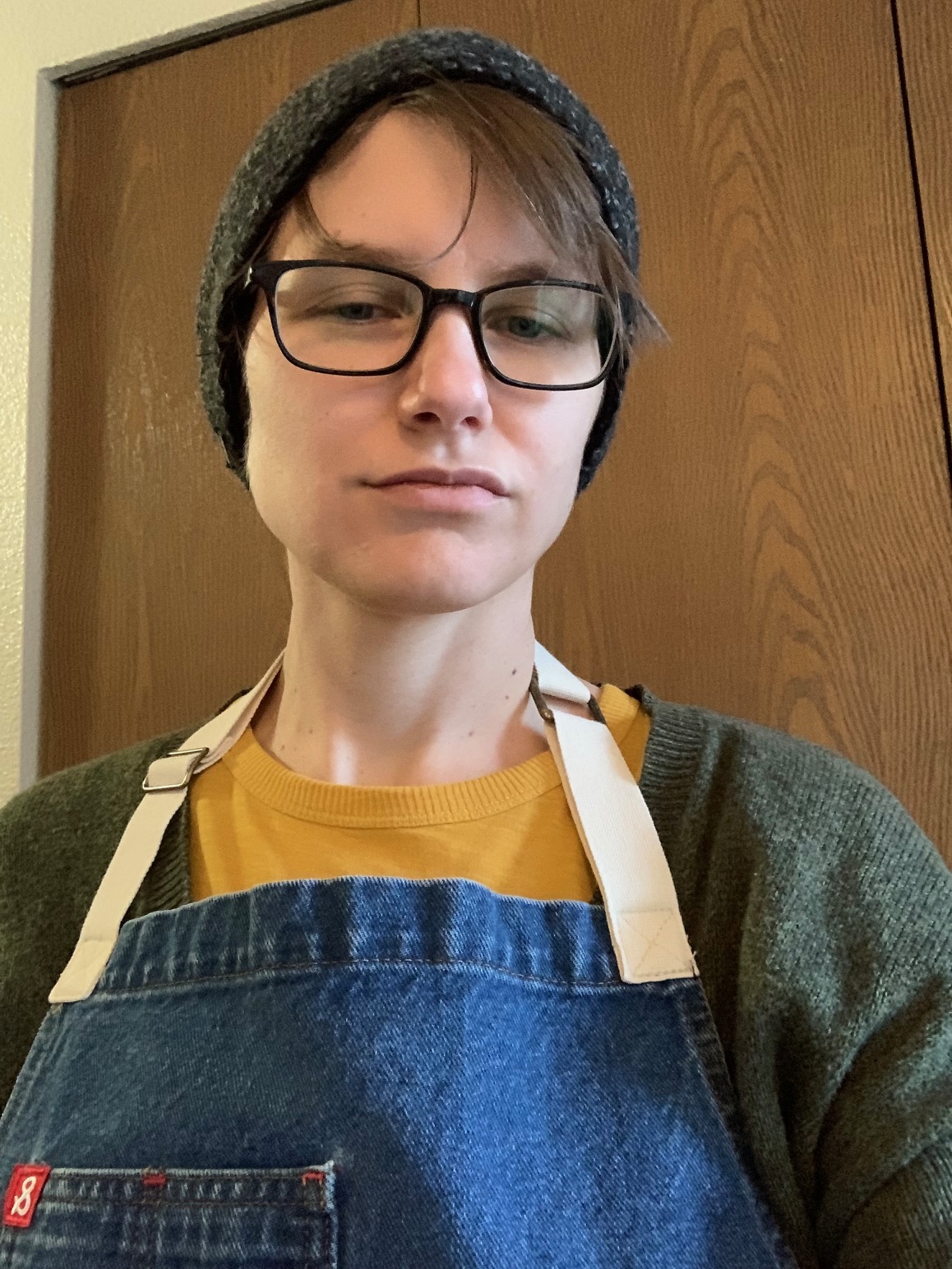 Laur Hawkins, a white person with short brown hair, rectangular glasses, and a knit beanie cap, shown from the shoulders up
